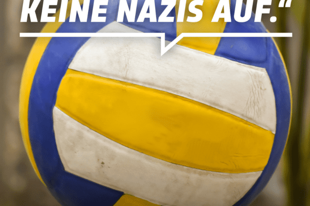 Nahaufnahme eines Volleyballs mit einer Protestbotschaft gegen Rechtsextremismus auf verschwommenem Hintergrund.