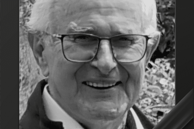 Portrait eines l&auml;chelnden &auml;lteren Mannes mit Brille, umrahmt von einem Trauerrand.