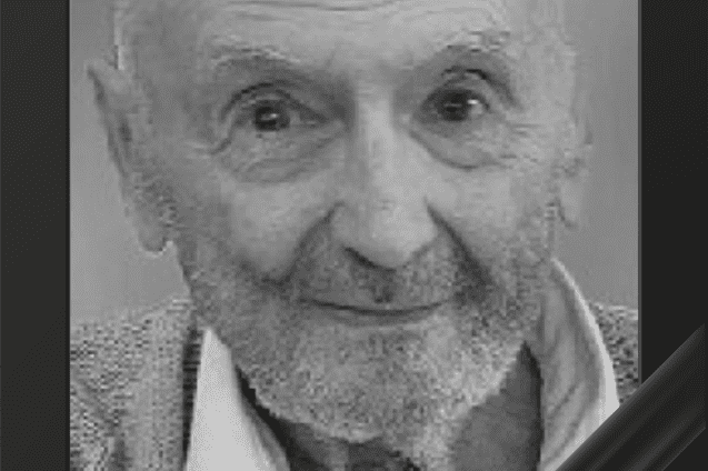 Portr&auml;t eines &auml;lteren Mannes mit Brille und Bart, umrahmt von einem schwarzen Trauerrand. Er l&auml;chelt freundlich.