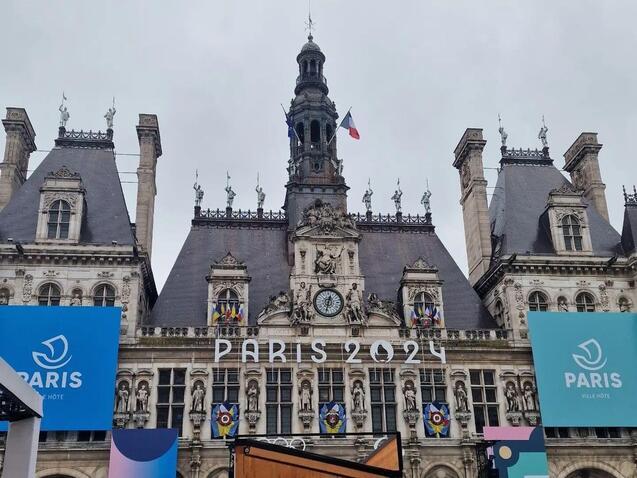 Blick auf das H&ocirc;tel de Ville in Paris, dekoriert f&uuml;r die Olympischen Spiele 2024 mit gro&szlig;en blauen Plakaten.