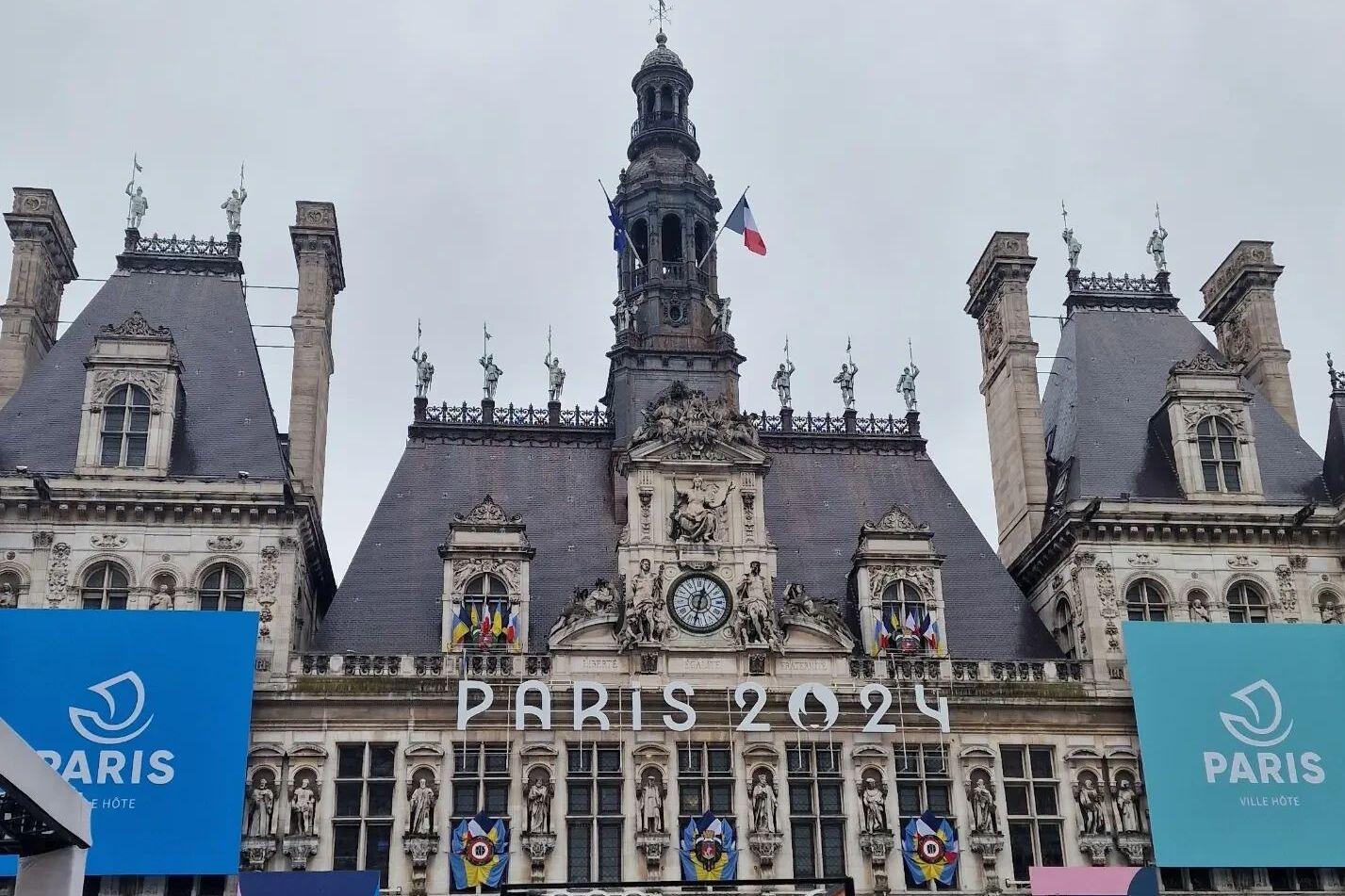 Blick auf das H&ocirc;tel de Ville in Paris, dekoriert f&uuml;r die Olympischen Spiele 2024 mit gro&szlig;en blauen Plakaten.