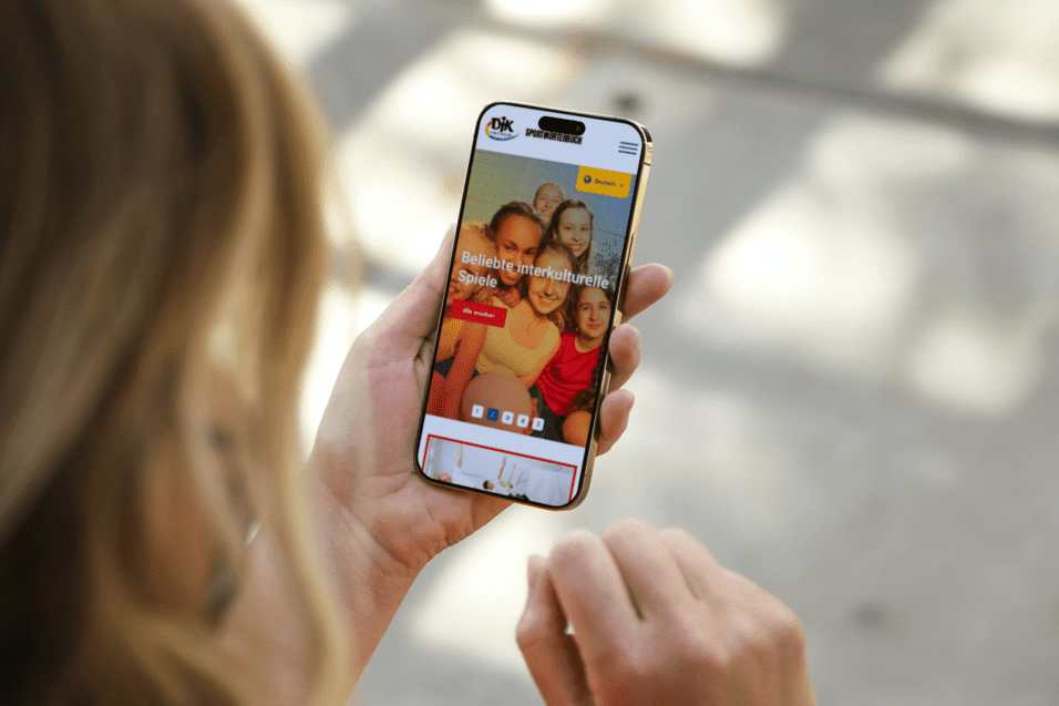 Nahaufnahme einer Person, die ein Smartphone mit einer Website &uuml;ber beliebte Unterhaltungsspiele h&auml;lt.
