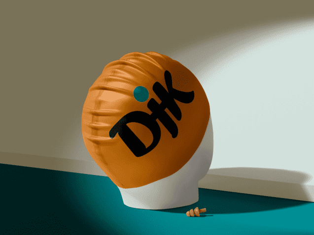 Schwimmkappe mit dem Aufdruck &bdquo;Dik&ldquo; auf einem Kopfmodell vor einer Wand, mit zwei kleinen Muscheln auf dem Boden.