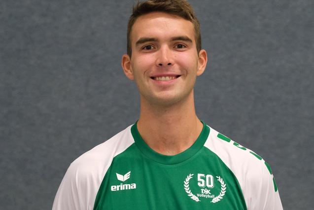 L&auml;chelnder Volleyballspieler in gr&uuml;nem Trikot mit Nummer 8, posing vor einem grauen Hintergrund.
