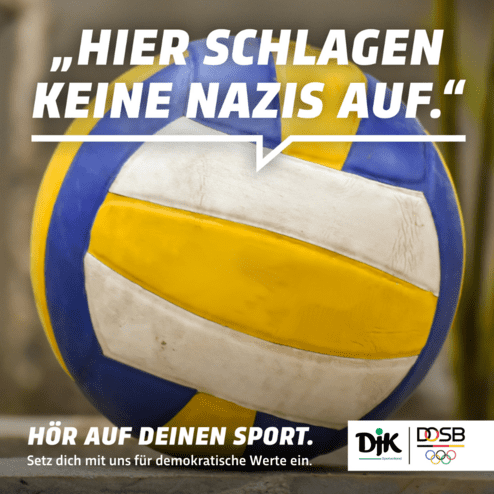 Nahaufnahme eines Volleyballs mit dem Slogan &bdquo;Hier schlagen keine Nazis auf&ldquo; auf unscharfem Hintergrund.