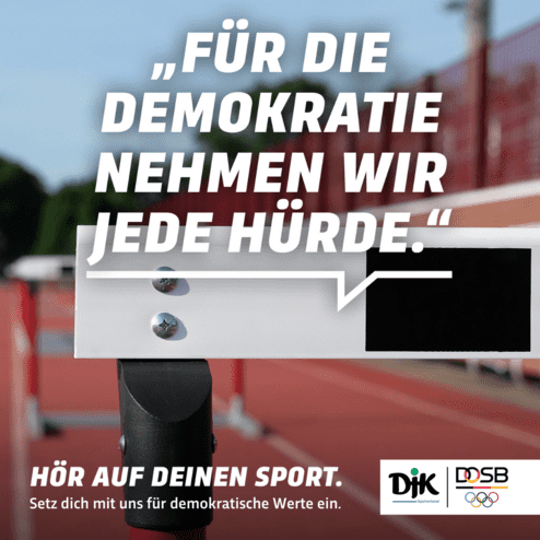 Nahaufnahme einer H&uuml;rde auf einer Laufbahn mit dem Slogan: &bdquo;F&uuml;r die Demokratie nehmen wir jede H&uuml;rde.&ldquo;