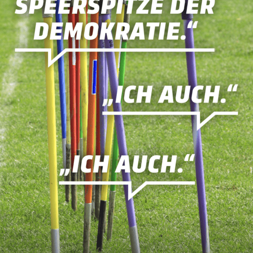 Bunte Sportger&auml;te stehen auf einem Rasen, umgeben von Sprechblasen mit Aussagen zur Demokratie.