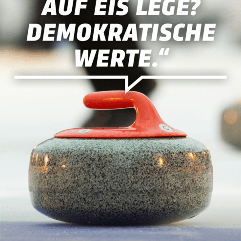 Nahaufnahme eines Curlingsteins mit rotem Griff auf einer Eisfl&auml;che, daneben ein verschwommener Spieler.