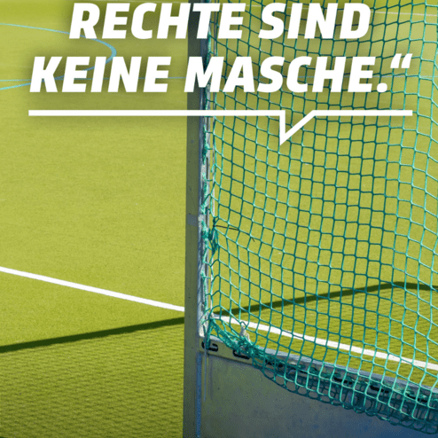 Zitat an einem Sportfeld: &bdquo;Menschenrechte sind keine Masche.&ldquo; Hintergrund zeigt ein Hockeytor und eine gr&uuml;ne Spielfl&auml;che.