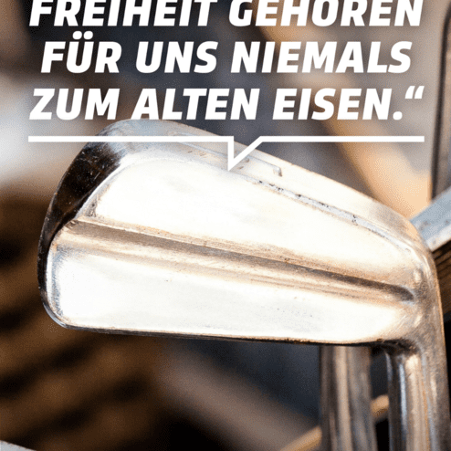 Nahaufnahme eines silbernen Golfschl&auml;gers mit einem Zitat zur Bedeutung von Demokratie und Freiheit im Sport.