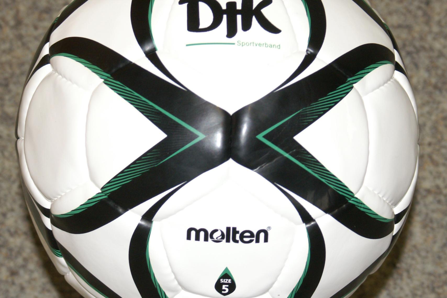 Aufsicht auf einen wei&szlig;en Fu&szlig;ball mit gr&uuml;nen und schwarzen Designelementen, beschriftet mit &bdquo;DJK&ldquo; und &bdquo;molten&ldquo;.
