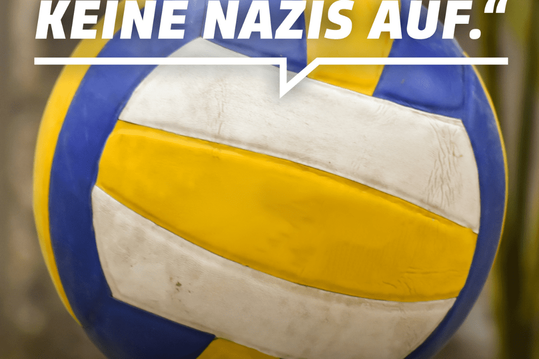Nahaufnahme eines Volleyballs mit einer Protestbotschaft gegen Rechtsextremismus auf verschwommenem Hintergrund.