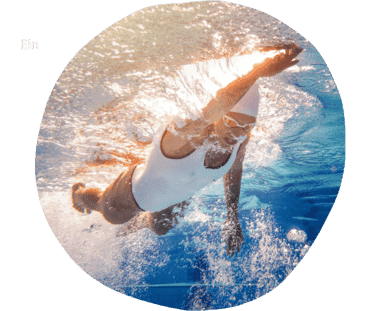Schwimmerin taucht dynamisch unter Wasser in einem klaren, blauen Schwimmbecken.