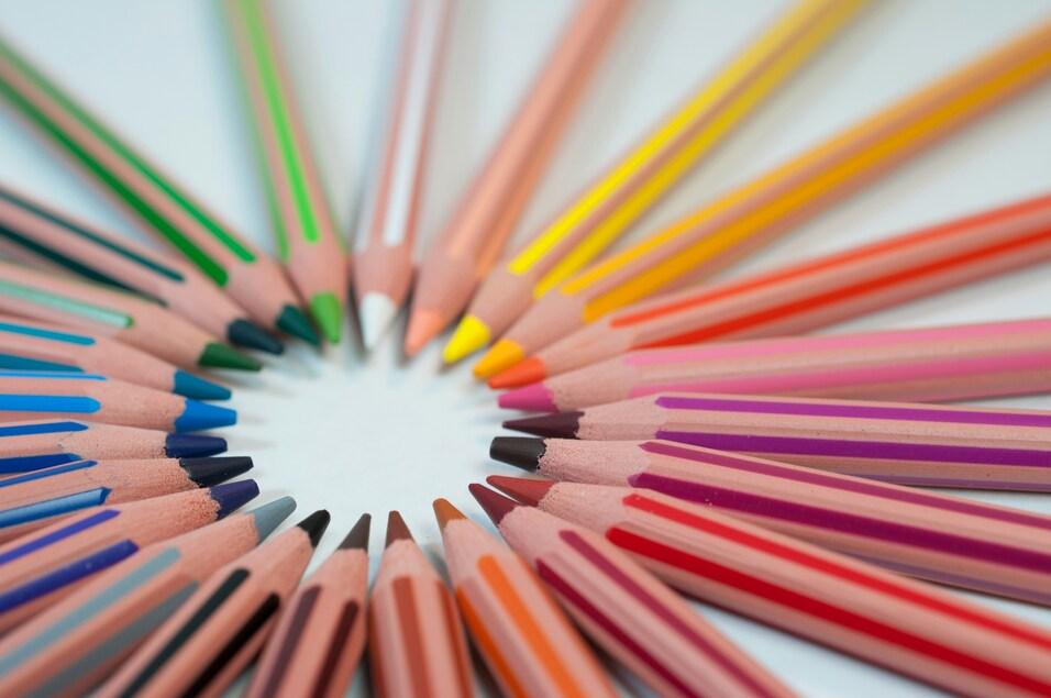 Kreisf&ouml;rmig angeordnete Buntstifte in verschiedenen Farben auf hellem Hintergrund.