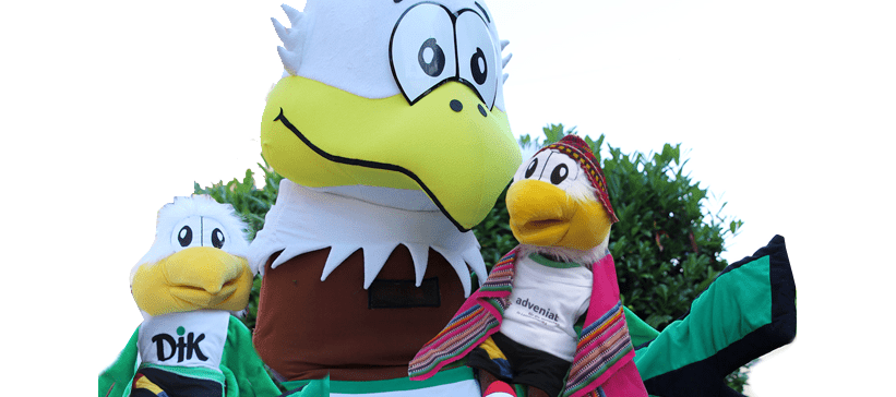 Drei bunte Stofftierfiguren stehen vor einer gr&uuml;nen Pflanzenkulisse, darunter ein gro&szlig;er Adler und zwei kleinere V&ouml;gel.