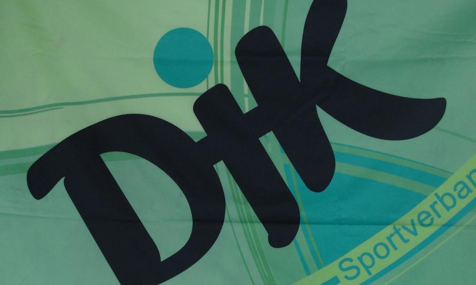 Fahne in Gr&uuml;n mit dem gro&szlig;en Logo &bdquo;DHT&ldquo; und dem Schriftzug &bdquo;Sportverband&ldquo; in blauer Schrift.