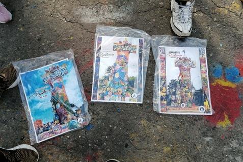 Drei farbige, einget&uuml;tete Magazine liegen auf einem graffiti-bedeckten Boden.
