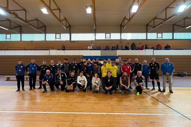 Gruppenfoto von 30 Personen in Sportkleidung in einer Sporthalle auf einem Holzfu&szlig;boden.