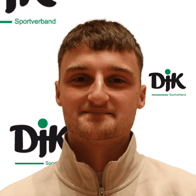 Portr&auml;t eines jungen Mannes mit kurzem Haar, der einen beigen Pullover tr&auml;gt, vor einem Logo des DJK Sportverbands.