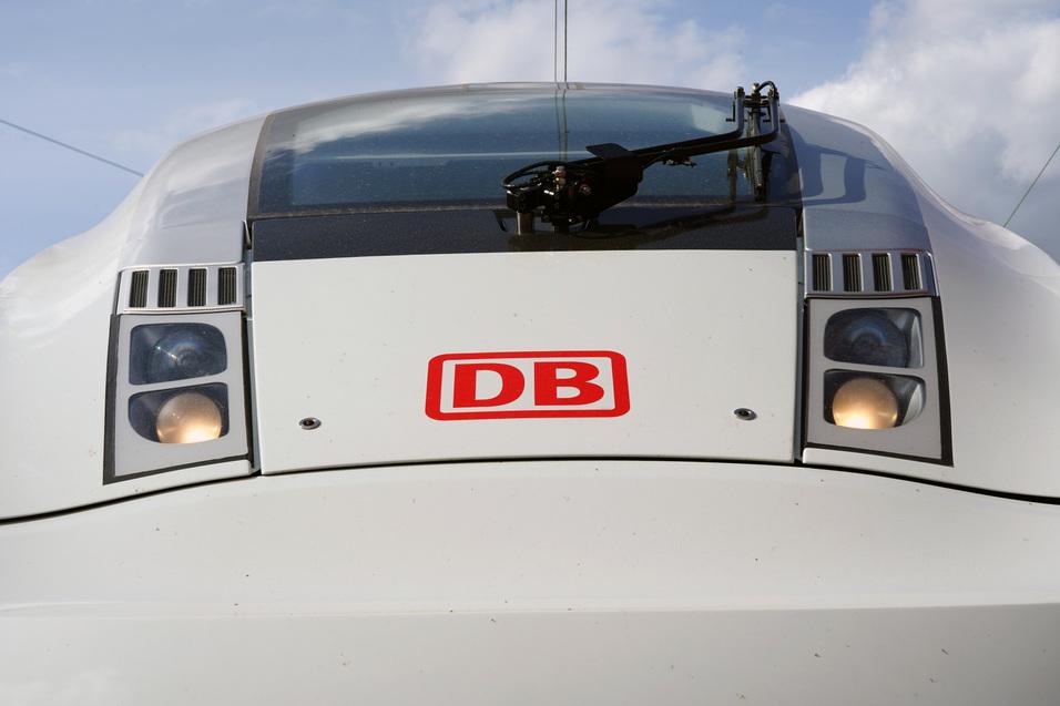 Nahaufnahme der Front eines wei&szlig;en Triebzuges der Deutschen Bahn mit dem DB-Logo und zwei sichtbaren Scheinwerfern.