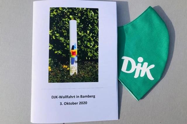 DJK-Wallfahrt in Bamberg: Programmheft und gr&uuml;ne Mundmaske auf einer Oberfl&auml;che.