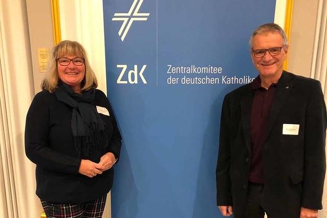Zwei Personen stehen l&auml;chelnd neben einem banner des Zentralkomitees der deutschen Katholiken (ZdK).