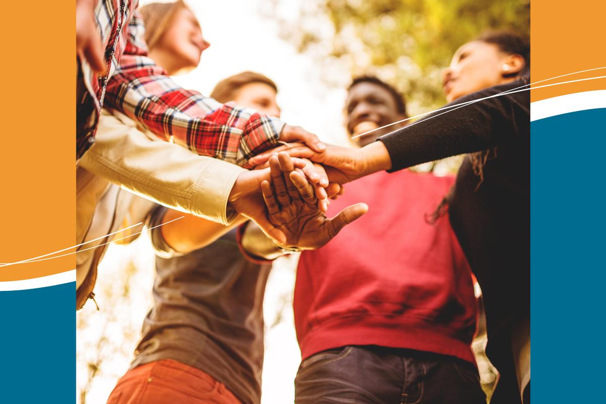 F&uuml;nf H&auml;nde treffen sich in der Mitte, um ein gemeinsames Ziel zu symbolisieren, vor unscharfem, nat&uuml;rlichem Hintergrund.