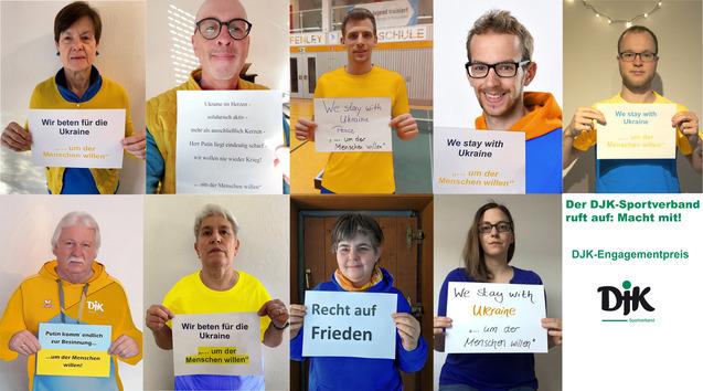 Gruppenfoto von Menschen, die Plakate mit Solidarit&auml;tsbotschaften f&uuml;r die Ukraine halten.