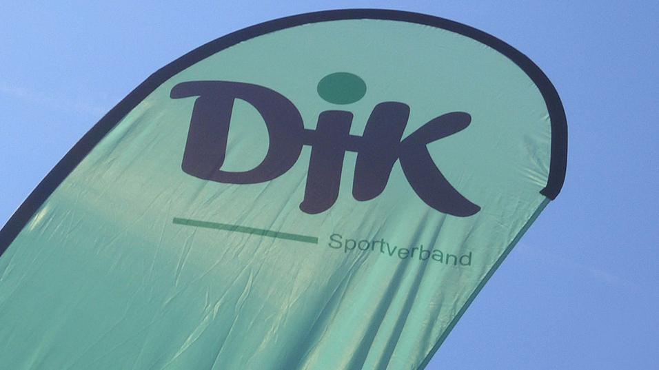 Gr&uuml;nes Banner mit der Aufschrift &bdquo;DJK Sportverband&ldquo; vor klarem Himmel.