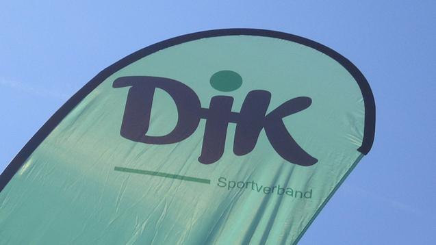 Gr&uuml;nes Banner mit der Aufschrift &bdquo;DJK Sportverband&ldquo; vor klarem Himmel.