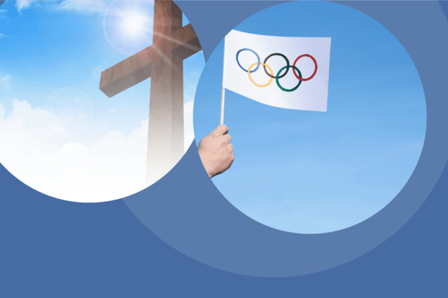 Hand h&auml;lt eine Fahne mit den Olympischen Ringen vor einem blauen Himmel und einem Holz-Kreuz im Hintergrund.
