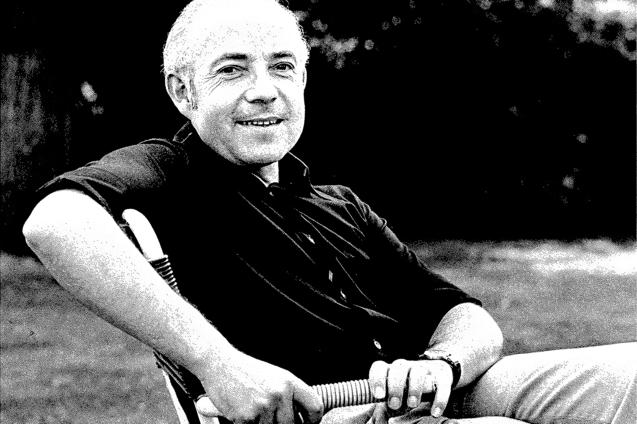 Portr&auml;t eines l&auml;chelnden Mannes, der entspannt auf einem Stuhl sitzt und einen Schlauch in der Hand h&auml;lt.