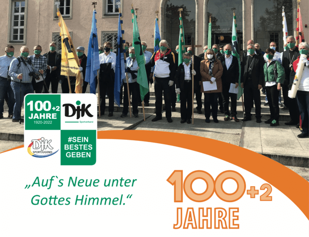 Gruppierung von Menschen mit Masken und Fahnen vor einem Geb&auml;ude, um das 100-j&auml;hriges Jubil&auml;um einer Sportorganisation zu feiern.